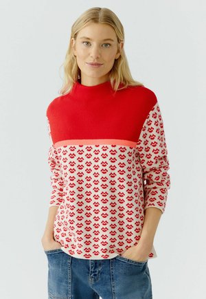 Rood en crèmekleurig gebreid sweater met een hoge hals, gekenmerkt door een golfpatroon over de onderhelft en lange mouwen. Casual pasvorm.
