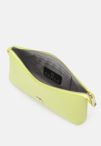 Pochette in pelle verde lime con zip dorata, fodera interna grigia e slot per carte multiple all'interno con etichetta del marchio.