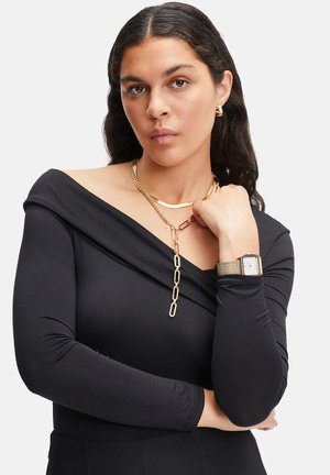 Schwarzes Off-Shoulder-Top aus glattem Stoff, mit geschichtetem Design, verziert mit goldenen Kettenhalsketten und einer Armbanduhr mit Mesh-Armband.