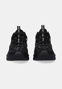 Zapatos deportivos negros con una parte superior de malla texturizada, acentos reflectantes, suela acolchada y cordones redondos. Presentan una etiqueta con la marca en la parte del talón.