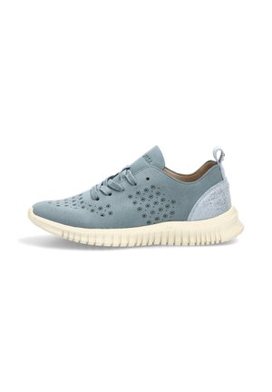 Zapatilla deportiva de ante azul claro con patrones circulares perforados, talón blanco texturizado, cierre frontal de cordones y suela blanca gruesa y flexible.