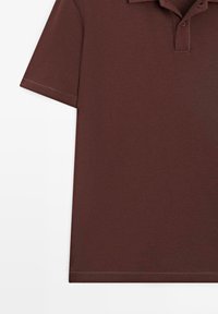 Brun kortærmet polo med krave og to-knaps lukning, vist fladt på hvid baggrund.