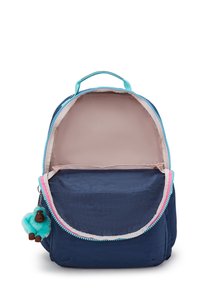 Sac à dos bleu marine avec un intérieur rose clair, fermeture éclair, et un porte-clés en forme de singe avec pompon turquoise. Présente un design simple et structuré.