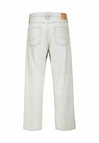 Jeans in denim chiaro mostrati da dietro con due tasche posteriori, passanti per la cintura e una targhetta di pelle marrone con il marchio sulla vita.