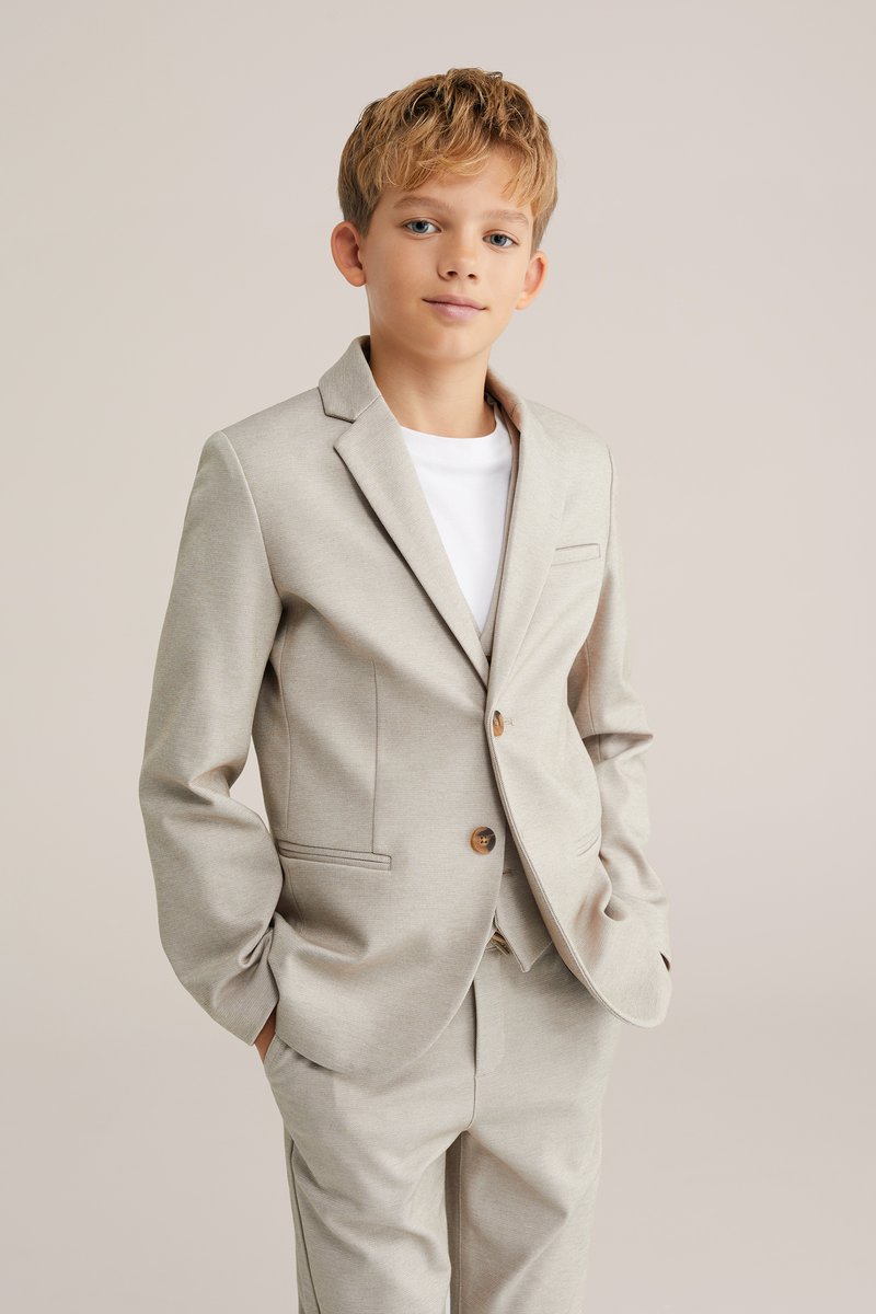 Helebeež põlvkonna ülikond, millel on sobiv jakk ja koosolekuga püksid. Omab kraeõmblust, ühte nuppu ja peent tekstuuri.