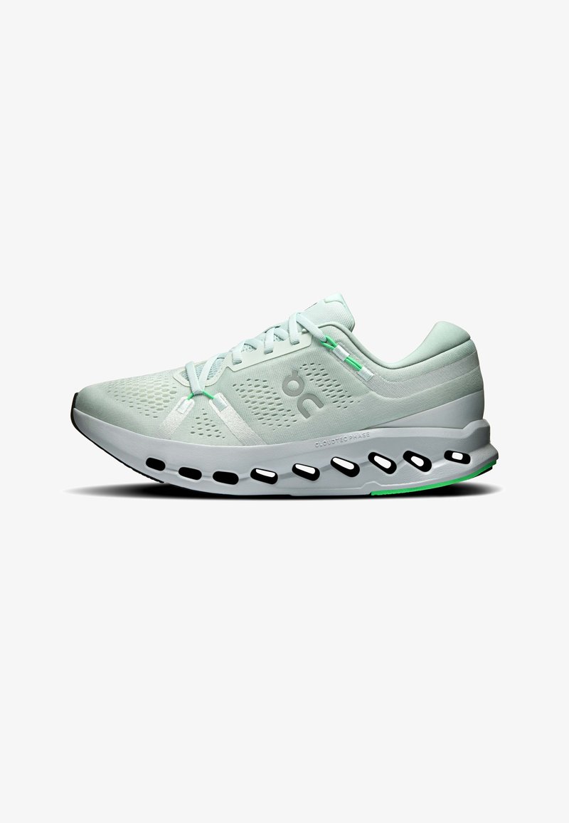 Chaussure de course athlétique vert clair avec empeigne en mesh ventilé, semelle unique ajourée, fermeture à lacets et petits détails verts.
