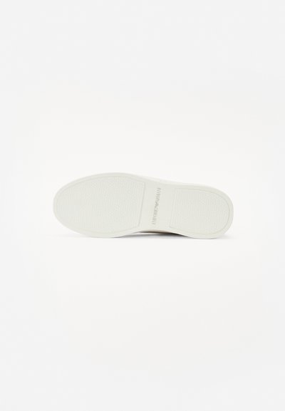 White rubber sneaker sole with a textured pattern and logo imprint. Smooth edges and rounded toe design, suitable for casual wear.