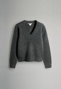 Pull gris foncé en matériau tricot doux, avec un profond col en V, des manches longues et des bords côtelés.