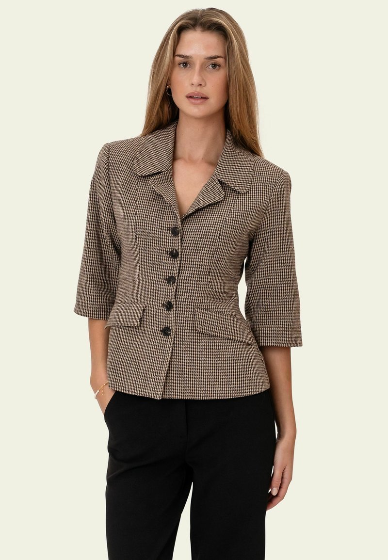 Blazer con motivo pied-de-poule marrone e nero, silhouette aderente, colletto ampio, maniche a tre quarti e sei bottoni neri.