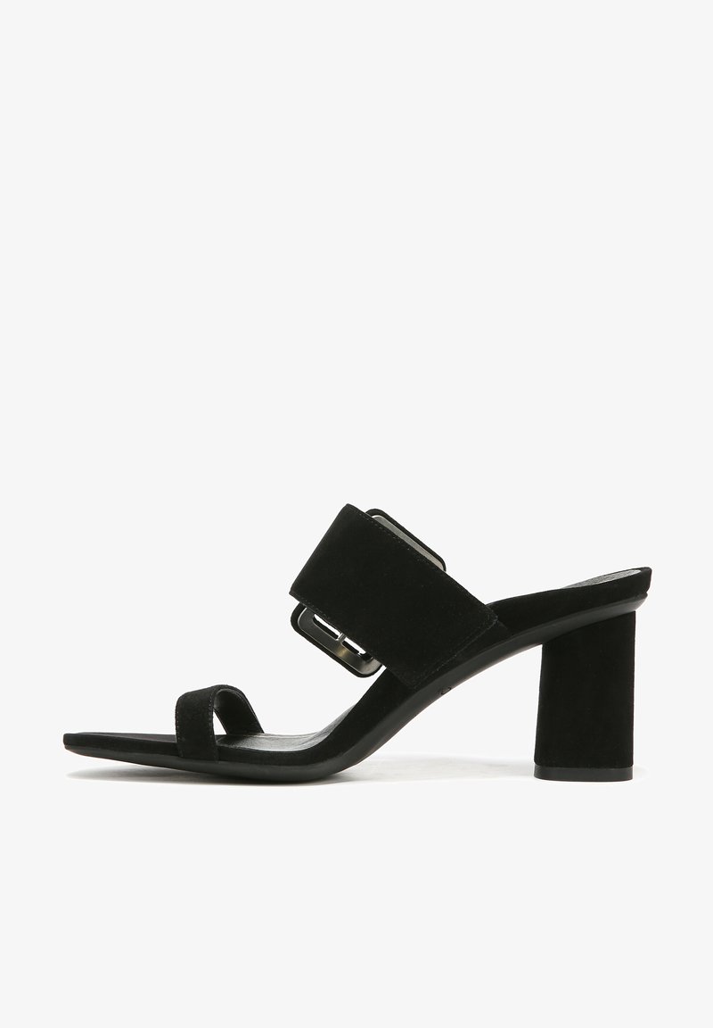 Black suede heeled sandals feature a wide upper strap with a metallic buckle, a narrow toe strap, and a chunky block heel.
