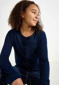 Námořnický modrý cardigan vyrobený z měkké pleteniny, s kulatým výstřihem, zapínáním na knoflíky a dlouhými rukávy. Jednoduchý a klasický design.