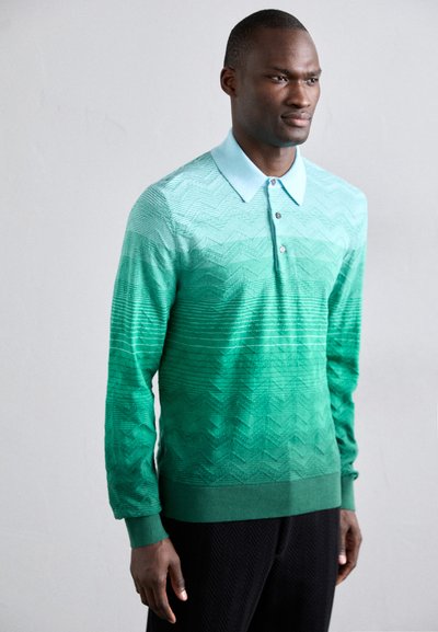 Zöld ombre polo pulóver világoskék gallérral, texturált Zig-zag mintákkal és laza szabással. Három gombos kivágás.