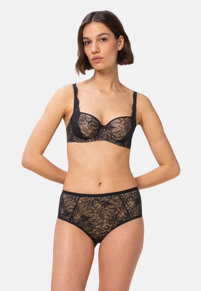 Ensemble soutien-gorge en dentelle noire et culotte taille haute avec motifs floraux, bords festonnés et bretelles délicates, présentant un design semi-transparent.