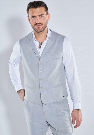 Light grey vest with a textured design, featuring a V-neck, five buttons, and two side pockets. Worn over a white collared shirt.