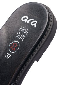 Černá kožená stélka s nápisem "ara High Soft", velikost "37" bílým písmem a dekorativním prošitím podél okraje. Texturovaný povrch detailu.