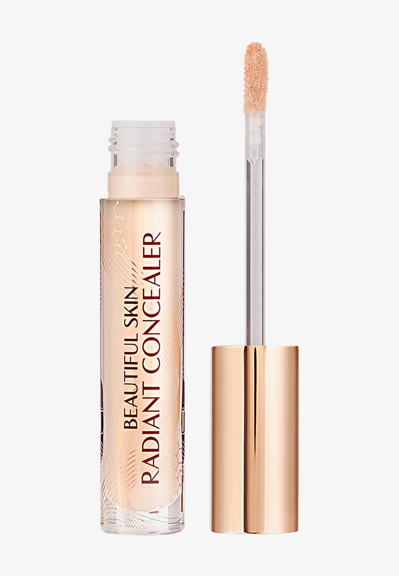 Clear tube of beige "Beautiful Skin Radiant Concealer" with rose gold cap and applicator wand showing creamy concealer on tip.
