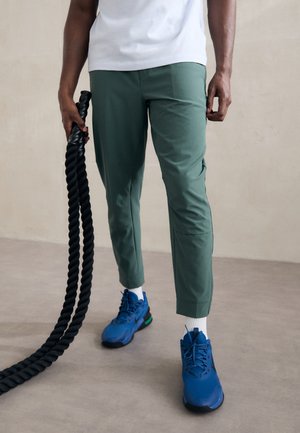Nike Performance UNLIMITED - Tracksuit bottoms - vintage green/black