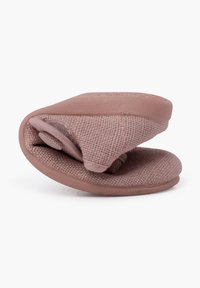 Zapatilla ergonómica de color rosa claro, hecha de tejido texturizado y goma, con un diseño plegado, suela lisa y detalles de costura mínimos.