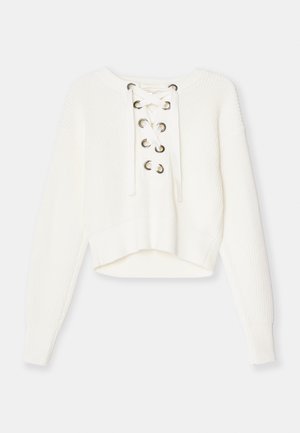 Maglione bianco corto realizzato in tessuto a maglia a coste. Caratterizzato da una scollatura con lacci e occhielli in metallo. Maniche lunghe e un orlo ampio a coste.