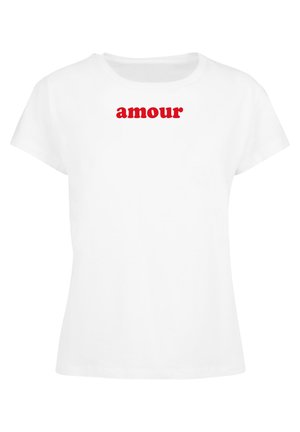 Biela bavlnená tričko s krátkymi rukávmi a okrúhlym výstrihom, na prednej strane s potlačou slova "amour" v tučných červených písmenách.