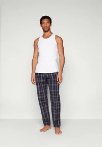 Pijamale masculine: un maieu alb din bumbac asociat cu pantaloni de pijama în carouri bleumarin, având nuanțe de albastru, roșu și verde, dintr-un material moale țesut.