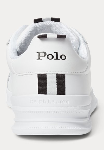 Weißer Polo-Sneaker mit schwarz-weiß gestreiftem Stoff-Zuglasche, schwarzem "Polo"-Logo an der Ferse und eingeprägtem "Ralph Lauren" auf der weißen Sohle.