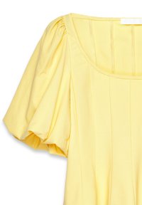 Gelbes Oberteil mit quadratischem Ausschnitt, gepufften Ärmeln und vertikalen Falten. Hergestellt aus weichem Stoff mit glatter Textur.