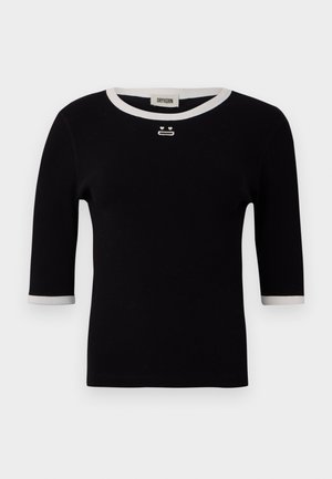 Svart kortermet topp med hvit kanting ved hals og ermer, med små broderte detaljer under halslinningen og strukturert ribbet stoff.