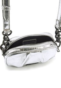 Borsa a tracolla metallizzata argento con finitura testurizzata, chiusura con zip e interno nero. Presenta una tracolla a catena e una forma arrotondata.
