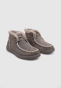 Botas de tobillo de ante gris con forro de pelo, que presentan un pespunte decorativo trenzado en la puntera y una suela de goma para mayor agarre.