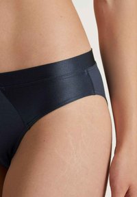 Marineblauwe bikini broekjes met een gladde satijnen afwerking; voorzien van een brede tailleband en naadloze zijkanten. Ontworpen voor comfort en een goede pasvorm.