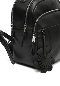Schwarzer Leder-Rucksack mit doppelten Reißverschluss-Schließungen, strukturierten Oberflächen und einem dekorativen schwarzen Blumenakzent an der Seite.