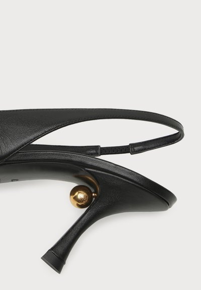 Μαύρο δερμάτινο γυναικείο παπούτσι slingback με ψηλό τακούνι, μυτερή μύτη και μοναδική χρυσή σφαιρική λεπτομέρεια κάτω από την καμάρα.