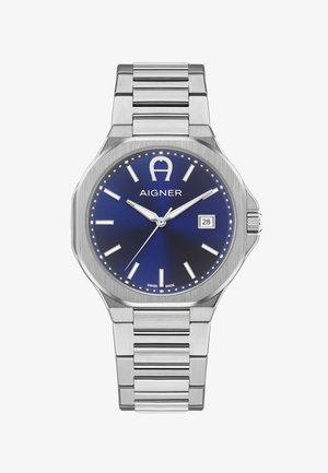 Montre bracelet en métal argenté avec cadran bleu, index blancs, affichage de la date à 3 heures et logo "Aigner" sous 12 heures.