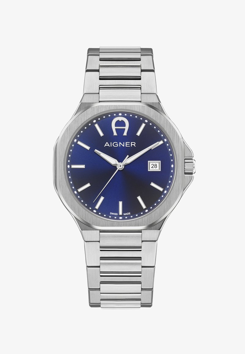 Reloj de pulsera de metal plateado con esfera azul, marcadores de hora blancos, pantalla de fecha a las 3 en punto y logotipo "Aigner" debajo de las 12 en punto.