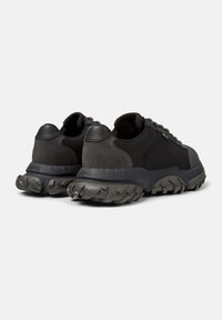 Czarne i szare buty sportowe z teksturowaną gumową podeszwą oraz sznurowanym designem, wykonane z połączenia gładkiego i zamszowego materiału.