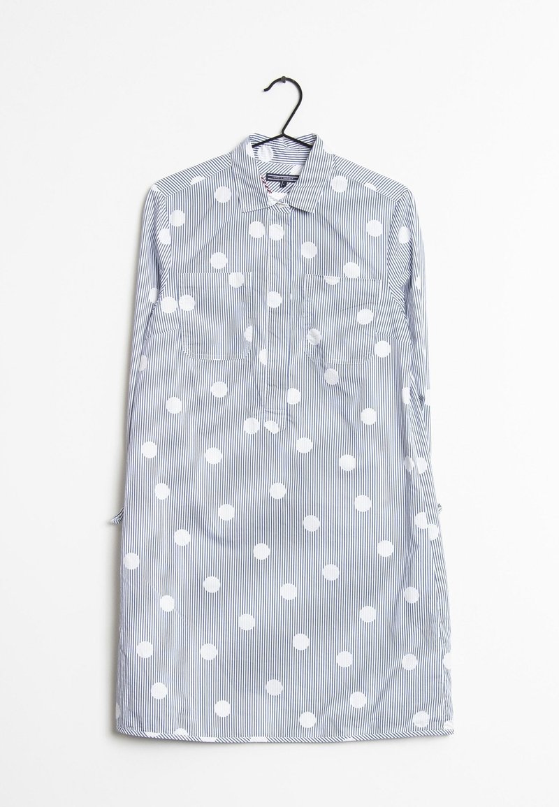 Camisa a rayas en azul y blanco con grandes lunares blancos. Presenta un collar tipo botón y dos bolsillos en el pecho. Tejido de algodón.