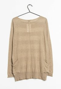 Beige långärmad topp tillverkad av mjukt stickat material. Har en rund halsringning, sidofickor och en lätt krökt nederkant.