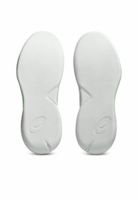 Semelles de chaussures de sport blanches avec surface texturée, forme de pointe arrondie et un accent vert près du talon. Présente un branding subtil.