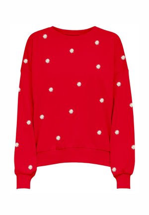 Punane pusa pikkade varrukatega, valgete lillemustritega, mis on laiali tikitud kanga peale. Lõdvestunud lõige ja soonikkoes mansetid.