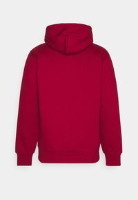 Red cotton hoodie featuring a hood, long sleeves, and ribbed cuffs and hem. Smooth texture and simple design without visible logos or patterns.
