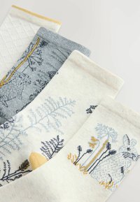 Vier Paar Socken in neutralen Farbtönen mit botanischen und tierischen Mustern wie Kaninchen, Schafen und Pflanzen auf hellem Hintergrund.