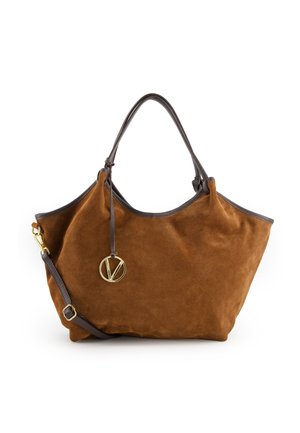 Bruine suède tote bag met een slouchy ontwerp, donkere leren handvaten en een gouden ronde charm. Inclusief verstelbare schouderriem.