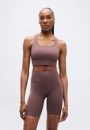 Brun atletisk crop topp og høytlivs shorts laget av glatt, strekkbart stoff, med et enkelt, tettsittende design uten synlige logoer.