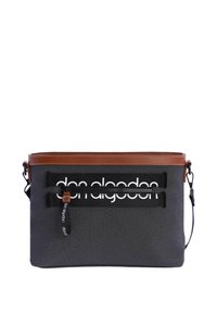 Bolsa rectangular de tela negra con detalles de cuero marrón, que cuenta con un bolsillo frontal con cremallera y un gran logo blanco, correa ajustable y superficie texturizada.