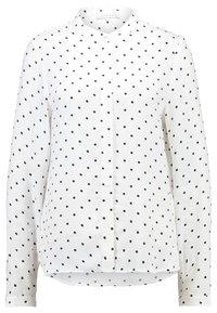 Blusa bianca a maniche lunghe con pois neri, apertura frontale con bottoni e un piccolo collo a camicia.
