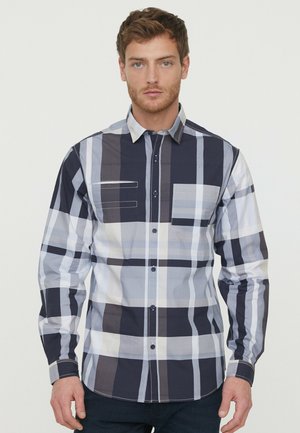 Langemouwen geruite shirt in navy, grijs en wit. Beschikt over een knoopsluiting aan de voorkant en een borstzak. Gemaakt van katoen met een gladde textuur.