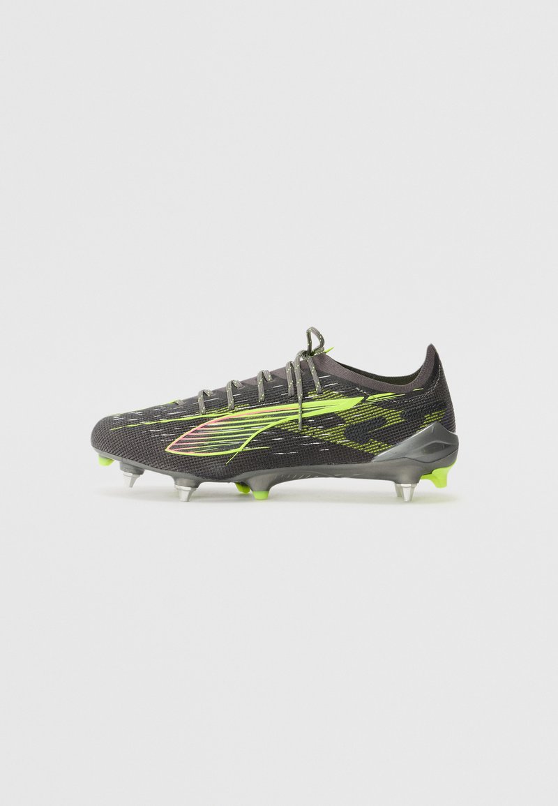 Black soccer cleat with neon green accents, textured fabric upper, and five conical studs on a molded rubber outsole.