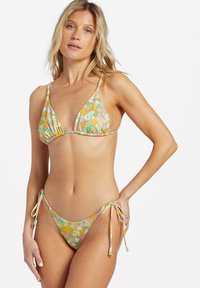 Set bikini floreale con top triangolo e culotte con lacci laterali. Il materiale è morbido, con una palette di colori pastello e una texture leggera.