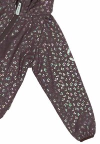 Lila regnrock med reflekterande lövmönster, zip-stängning, elastiska ärmslut och huva. Tillverkad av vattentätt material för utomhusbruk.